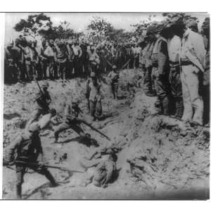 Japanese soldiers bayoneting captured Chinese soldiers in trench;1937 