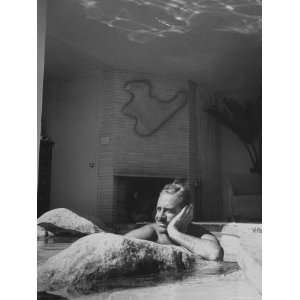 Industrial Designer Raymond Loewy Relaxing in Rock Filled Pool at His 